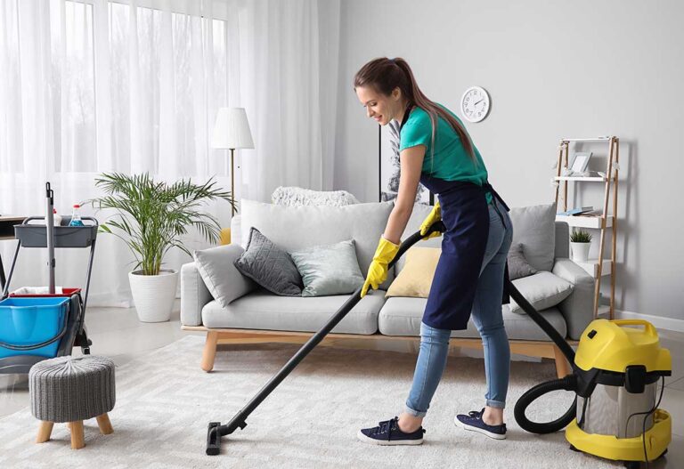 Person scrubbing bathroom grout while cleaning tools and supplies sit nearby.